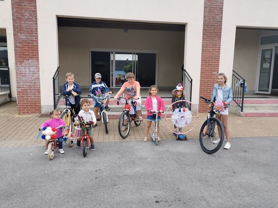 Les enfants présentant leur création pour le concours de vélos fleuris