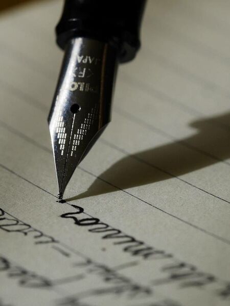 Cahier avec écritures et stylo plume noir
