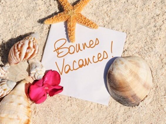 Affiche bonnes vacances posé sur le sable entouré de coquillages