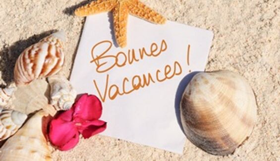 Affiche bonnes vacances posé sur le sable entouré de coquillages